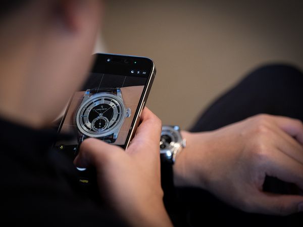 A collector takes a wrist shot of Aaron Becsei's Pameus in platinum at Phillips Geneva.