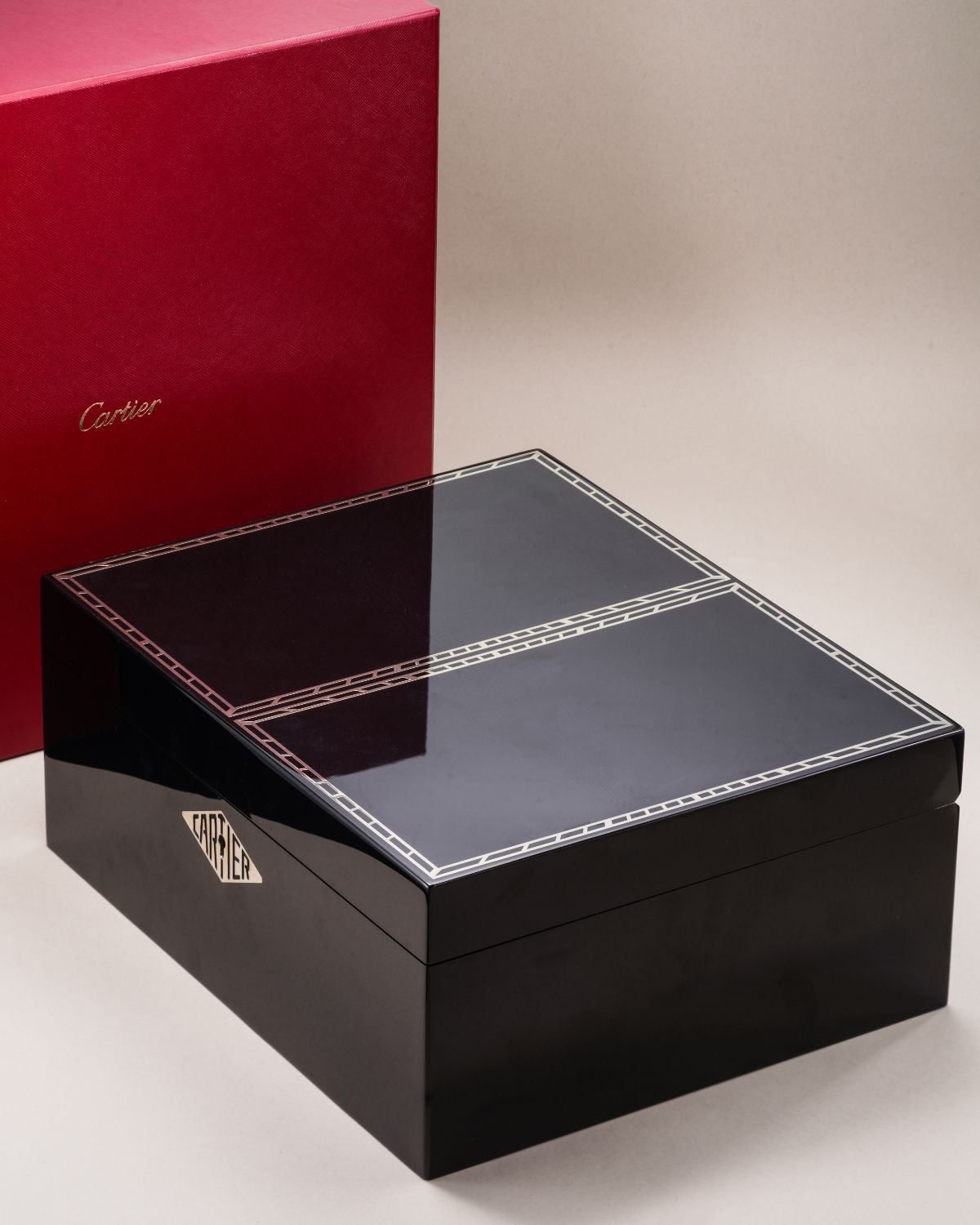 Lot 93: A limited-edition Cartier watch box in red grained leather and black lacquer with chemin de fer decoration, included in the Phillips Geneva Sessions, Fall 2026, Online Auction. Estimate: CHF 3,000–6,000
