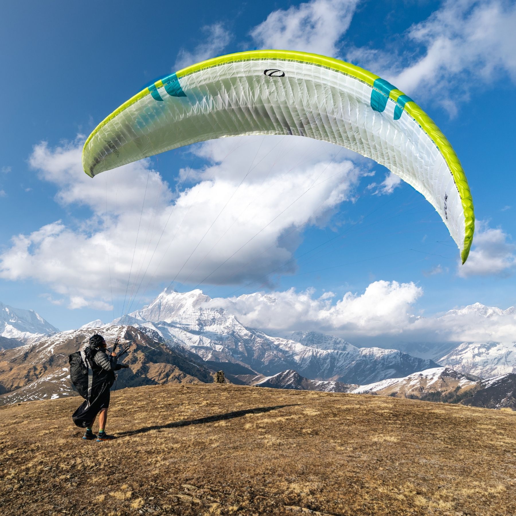 Man in the moutains about to set off paragliding. 