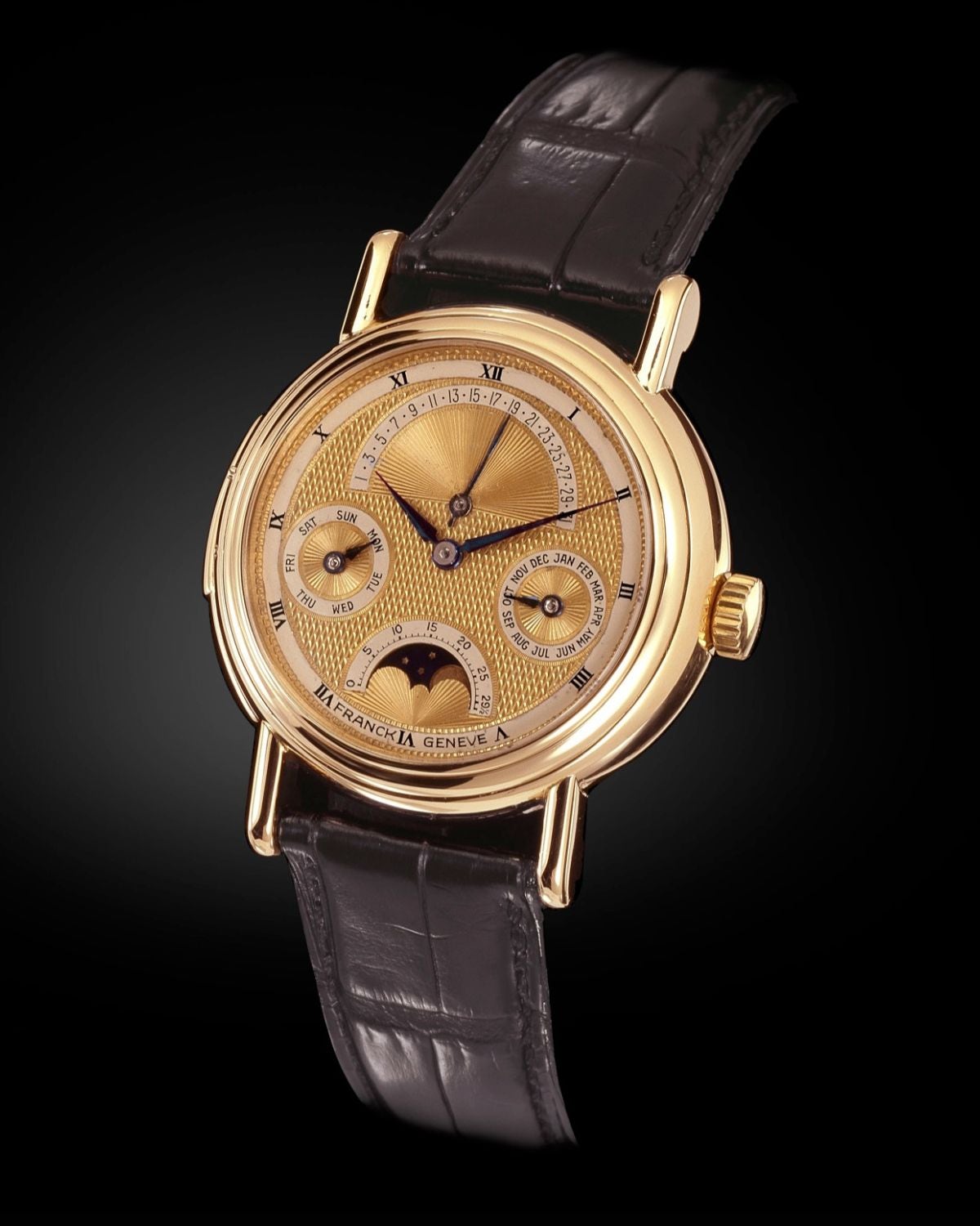 A Franck Genève wristwatch, dated 1983 in Franck Muller’s archives, with a retrograde date, day and month indications, and moon phases on an engine-turned gold dial. Franck Muller