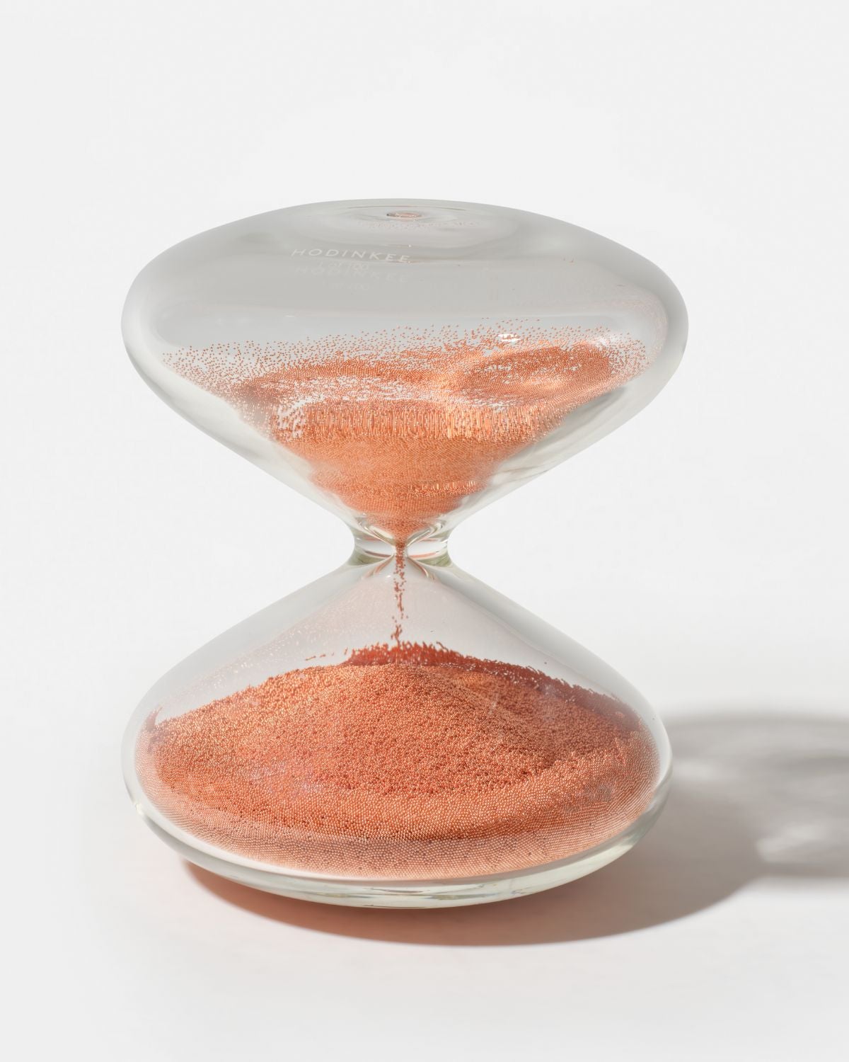 Lot 53: A 2022 Marc Newson × HODINKEE Hourglass Ref. HG10 Copper in hand-blown borosilicate glass with copper-coated stainless steel nanoballs, one of a limited edition of 100 pieces, included in the Phillips New York Sessions, Fall 2026. Estimate: USD $10,000–20,000