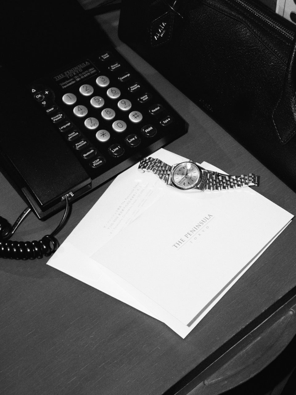 A Rolex DateJust, purse, notepad, and telephone bedside in a room at the The Peninsula Tokyo.