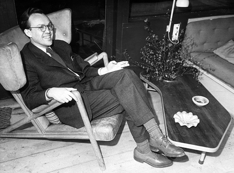 Finn Juhl seated in his ‘Grasshopper’ chair in front of a model coffee table. Photo: © Designmuseum Denmark Archive. 